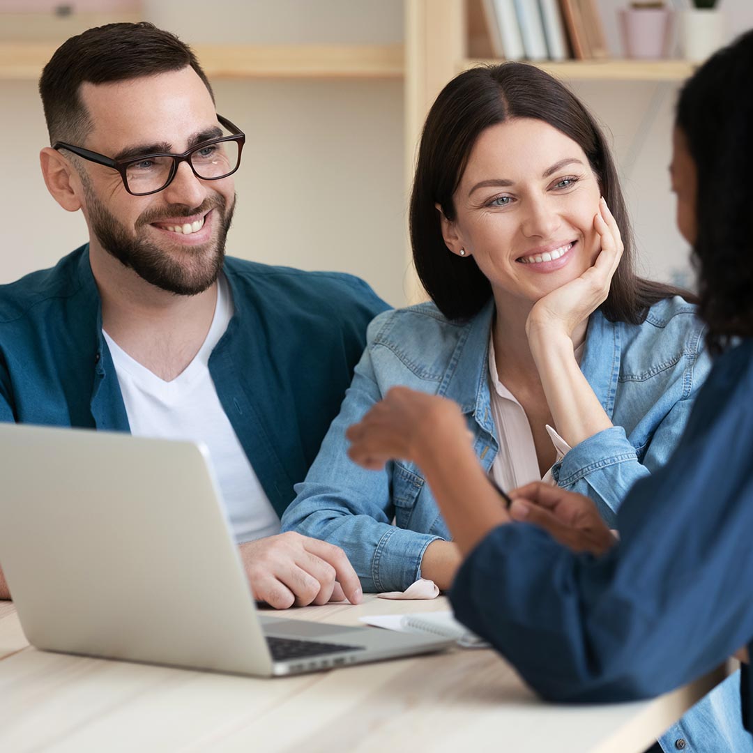 Smiling couple talking to financial management manager