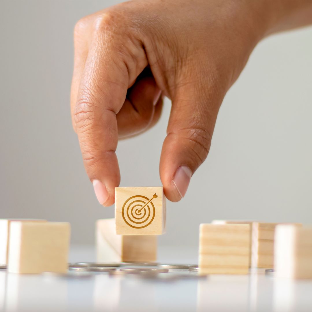 Man holding block with bullseye icon on it