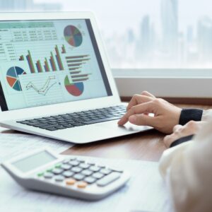 A laptop with several financial graphs on the screen.